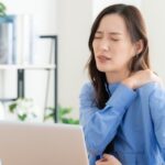 慢性的な肩こりで仕事に集中できない女性