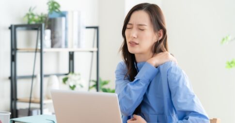 慢性的な肩こりで仕事に集中できない女性
