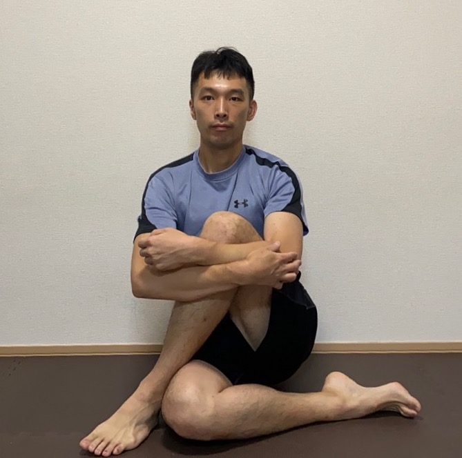 中殿筋ストレッチを行う男性トレーナー